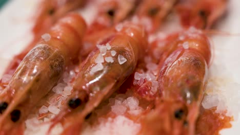 Un-Plato-De-Camarones-Rojos-Con-Mariscos-Cocidos-Al-Horno-Se-Presenta-En-Un-Plato-Blanco-Limpio,-Realzado-Con-Una-Delicada-Pizca-De-Sal-Marina.