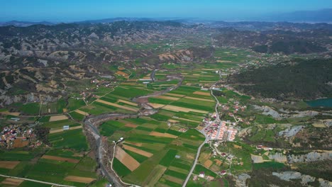 Countryside-Stunning-Village-Landscape-in-the-Valley-with-Green-Parcels,-Spring-Agriculture-Amidst-the-Rolling-Hills-in-Albania