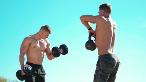 young sportsman workout. handsome athletes doing exercises with dumbbells