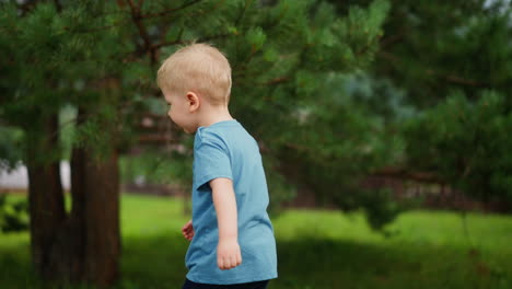 toddler child surprises when pine cone strikes arm in forest