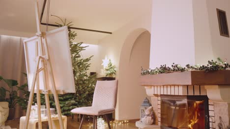 wooden easel with canvas stands in living room by live fireplace