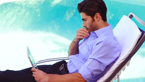 handsome man using tablet on deck chair