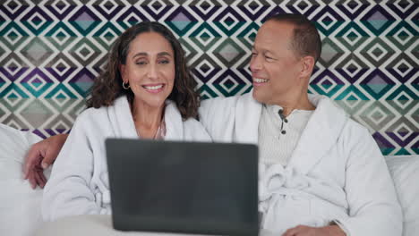 couple using a laptop in bed
