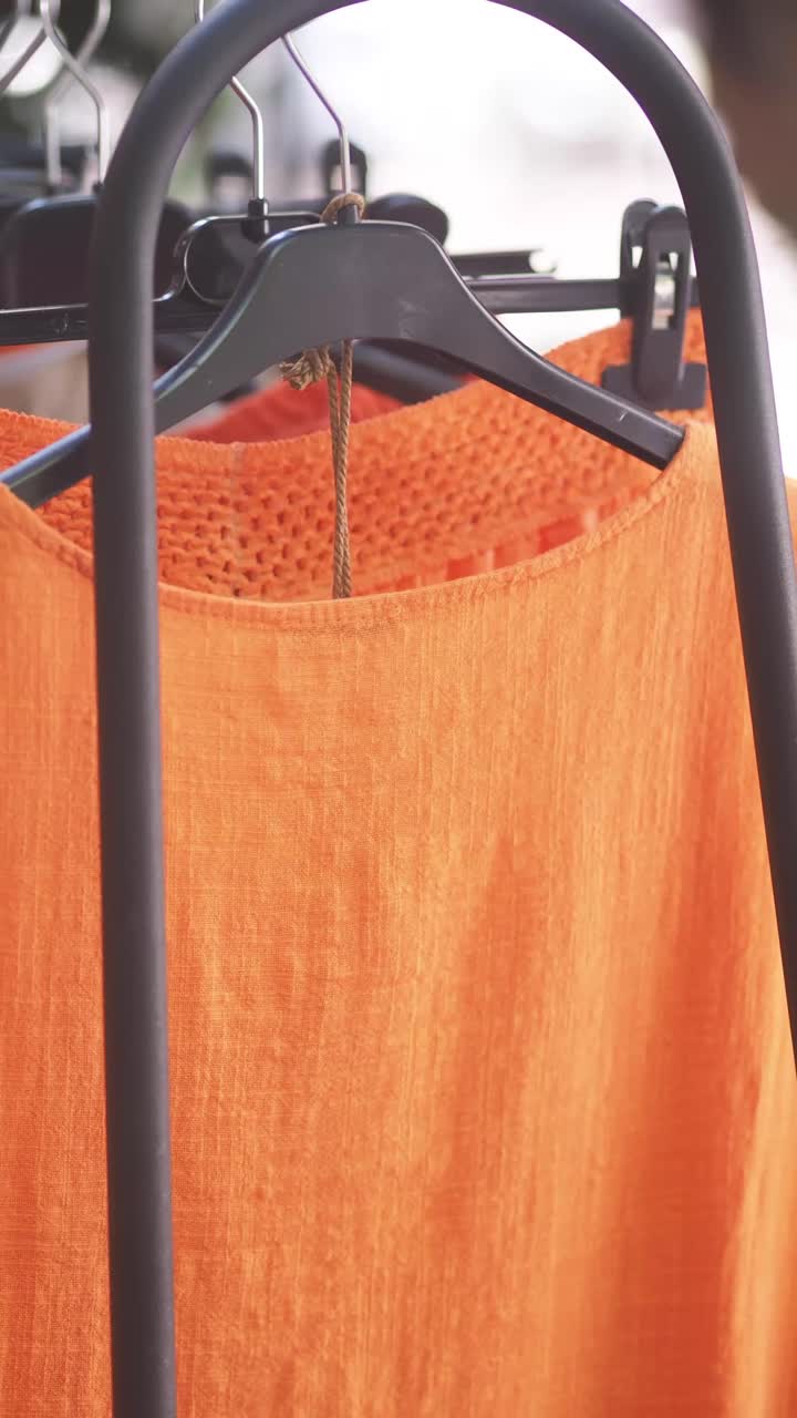 Close-up of Orange Clothing Hanging on a Rack