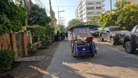 un tuk-tuk se mueve a lo largo de una concurrida carretera urbana.