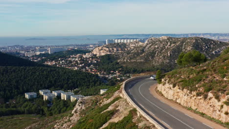 flying over a mountain road and revealing marseille city in france