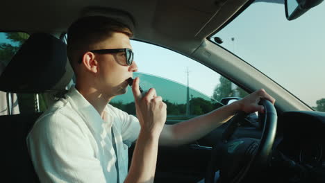 a young driver smokes an electronic cigarette while driving