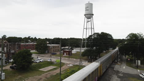 freight train passes water tower in small texas town