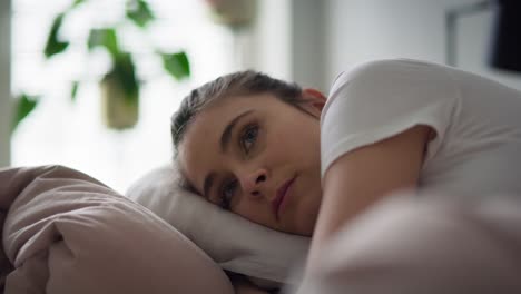 vídeo en primer plano de una mujer deprimida acostada en la cama