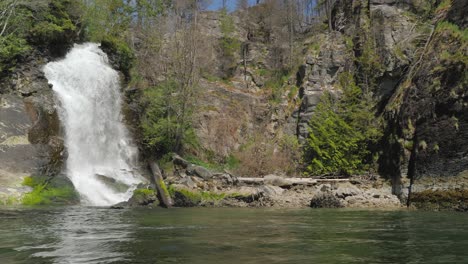 wide slider, slow motion shot of a waterfall flowing into the ocean