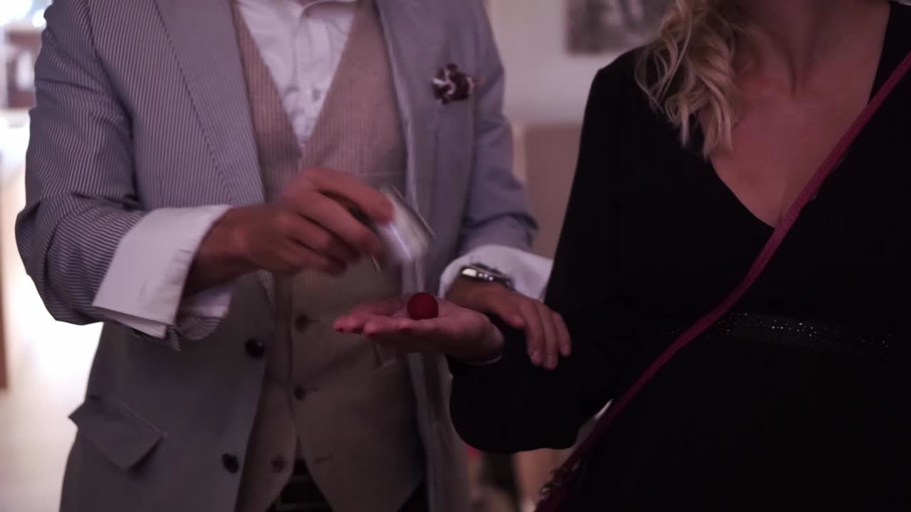 Magic trick with red ball during party in slow motion