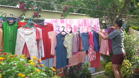 filipina lady doing household chores and drying the hanging laundry clothes at the orphanage home in the philippines - static shot