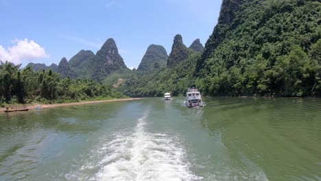 two sightseeing boats carrying tourists on a journey on the magnificent li river from guilin to yangshuo, china
