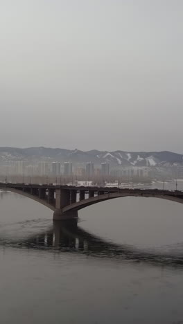 bridge over a river in a misty cityscape