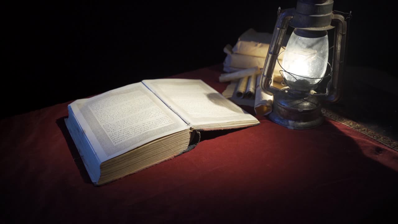 Libro storico alla luce di una vecchia lampada a olio