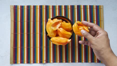 hand picking sliced jackfruit from bowl