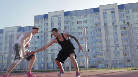 two men playing basketball on a street court