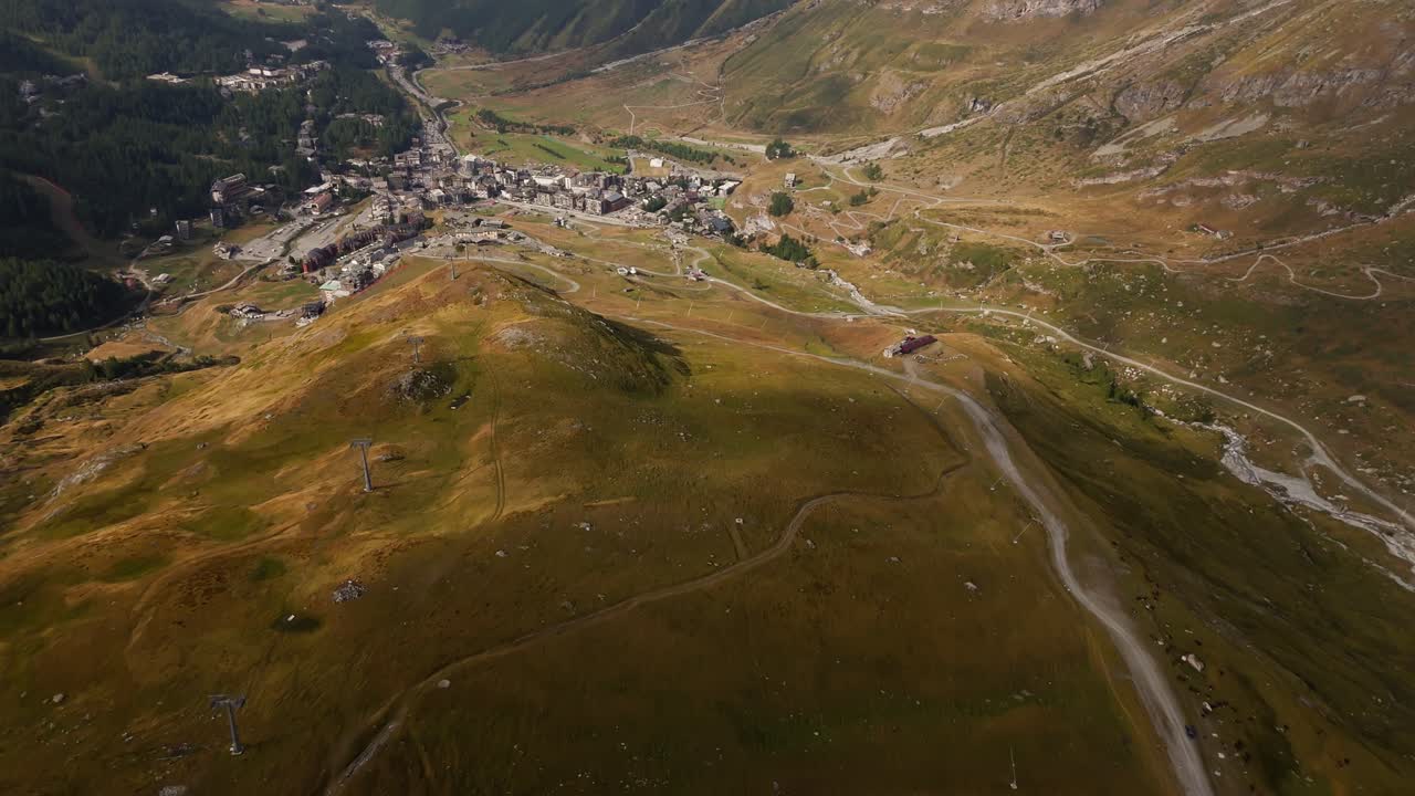 Ripresa aerea ascendente di un paesaggio pittoresco che rivela una piccola città a Cervinia, Italia, Valle d'Aosta, che mostra uno scenario alpino