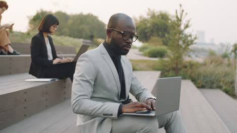 Afroamerikanischer-Geschäftsmann,-Der-Im-Park-Am-Laptop-Arbeitet