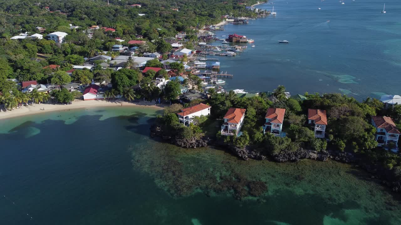 Sorvolo di ville sul lungomare sulla costa della Roatan caraibica, Honduras.