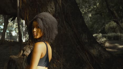 reina caribeña de cabello natural parada a la luz del sol en un parque en la isla caribeña de trinidad