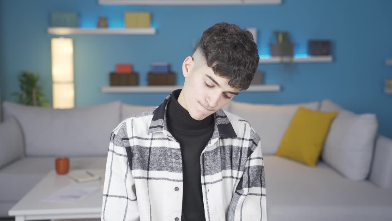 지루하고 우울한 젊은이가 불행하게 카메라를 쳐다보고 있습니다.