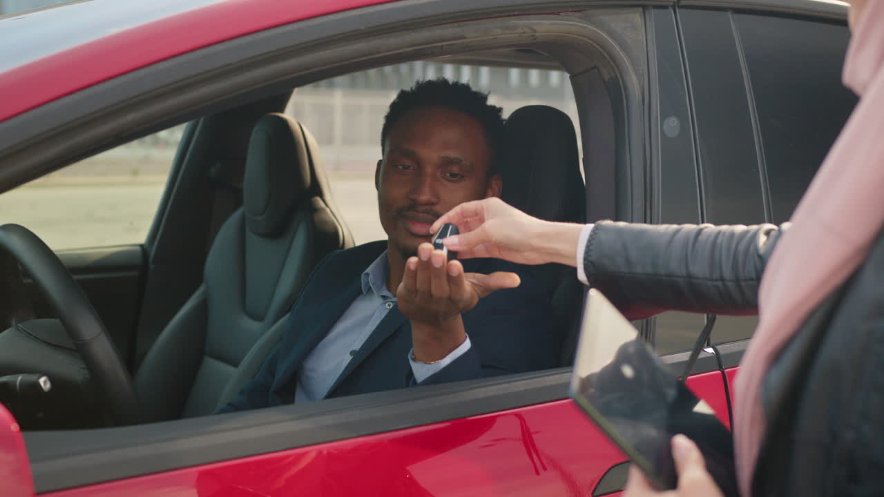 hombre de negocios recibiendo las llaves del coche de una mujer