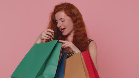 mujer joven elegante adicta a las compras que muestra bolsas de compras, publicidad de descuentos precios bajos en los días festivos