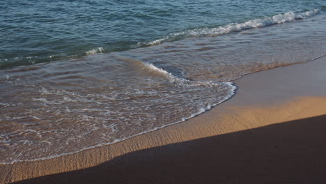 serene waikiki beach with blue water and ocean waves on sunny day, hawaii, slow motion