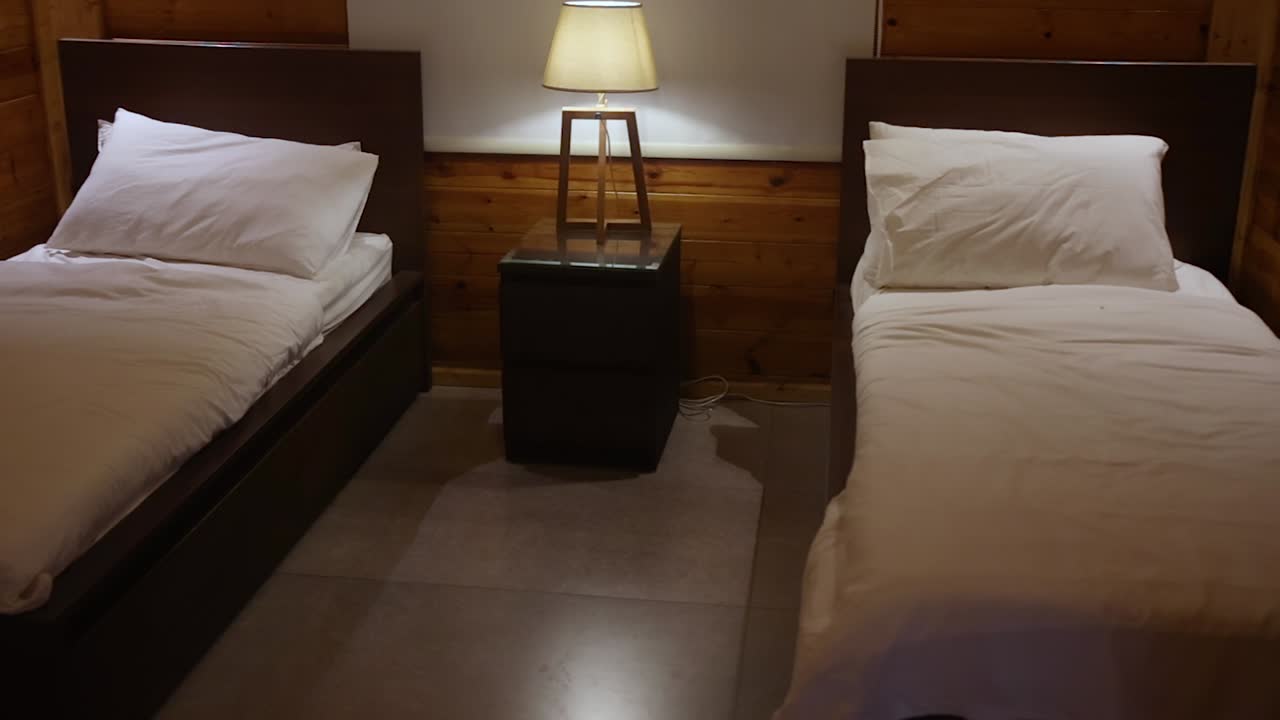 싱글 침대 2개가 있는 침실 내부의 공중 팬 오른쪽 샷