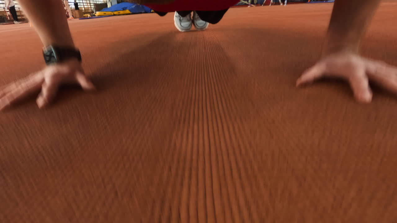 Person Performing Push-ups on a Gym Floor