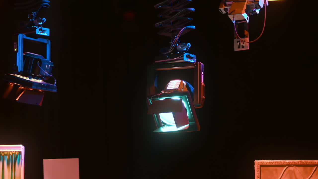 Grid of professional lighting fixtures suspended in a dark television studio