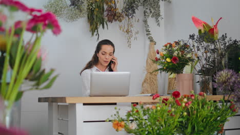 florista de negocios hablar teléfono inteligente en línea en la tienda de flores. mujer trabajo dispositivo portátil