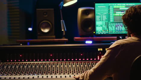 ingeniero de sonido grabando y editando pistas en la sala de control