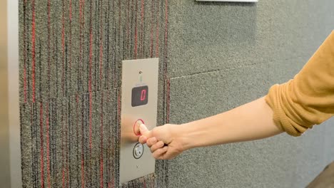 Impatient-female-employee-is-pressing-an-elevator-button