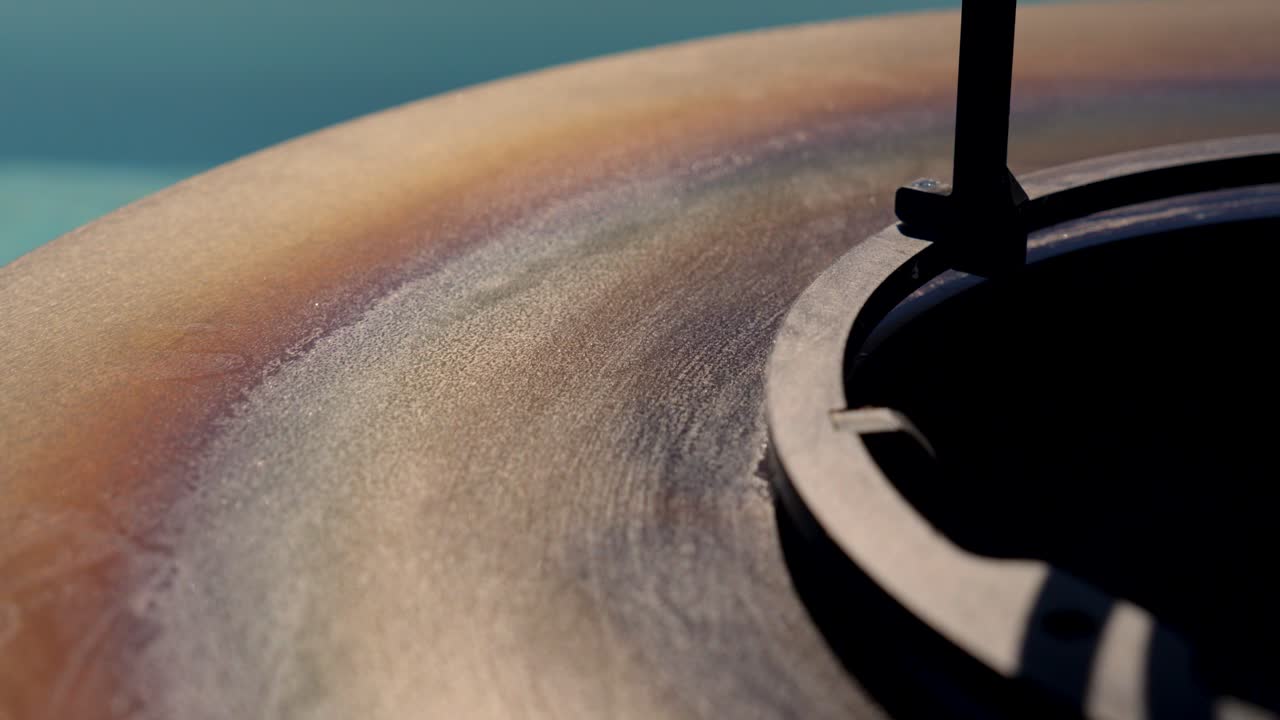 Primo piano della superficie di un braciere in metallo stagionato che mostra la patina di calore