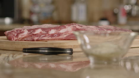 el enfoque del estante desde costillas de cerdo crudas a un plato de sal y especias.
