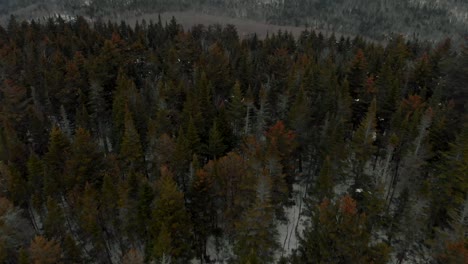 Imágenes-Aéreas-De-Drones-De-Una-Tarde-Nevada-En-La-Cima-De-Una-Montaña-Con-Un-Acantilado-Escarpado-Y-Una-Vista-Increíble-De-Un-Lago-Congelado-En-Medio-Del-Invierno-Canadiense-En-Quebec