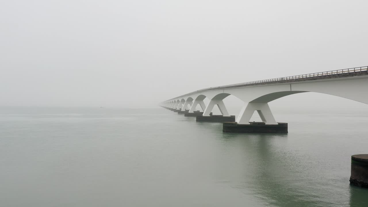 네덜란드의 짙은 안개 속에서 섬 사이를 가로지르는 긴 다리의 공중 전망