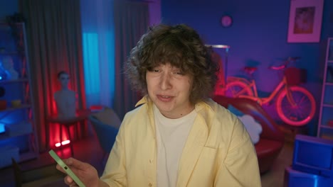 man making a video call/live stream in a colorful home studio