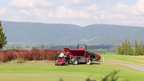 tractor atravesando y trabajando en un campo de golf.