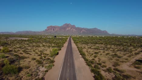 long desert highway leading straight to mountains in hot arid southwestern landscape