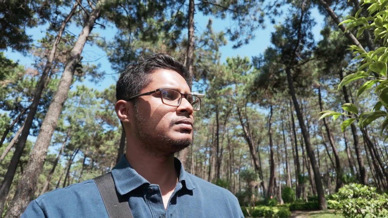 Giovane uomo in piedi in una pineta