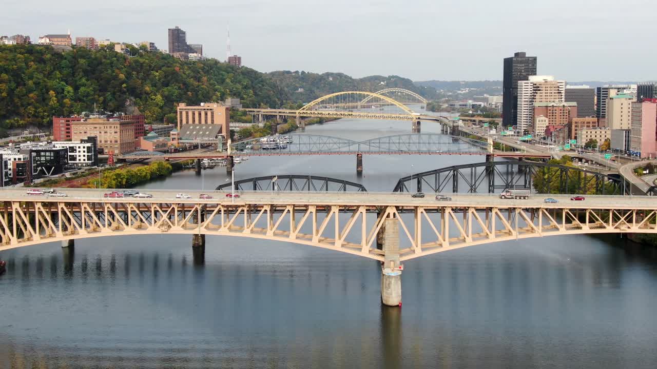 Aerial tilt-up reveals bridges and traffic across Monongahela River in Pittsburgh, PA, USA