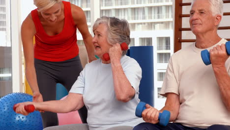 trainer helping senior citizens work out