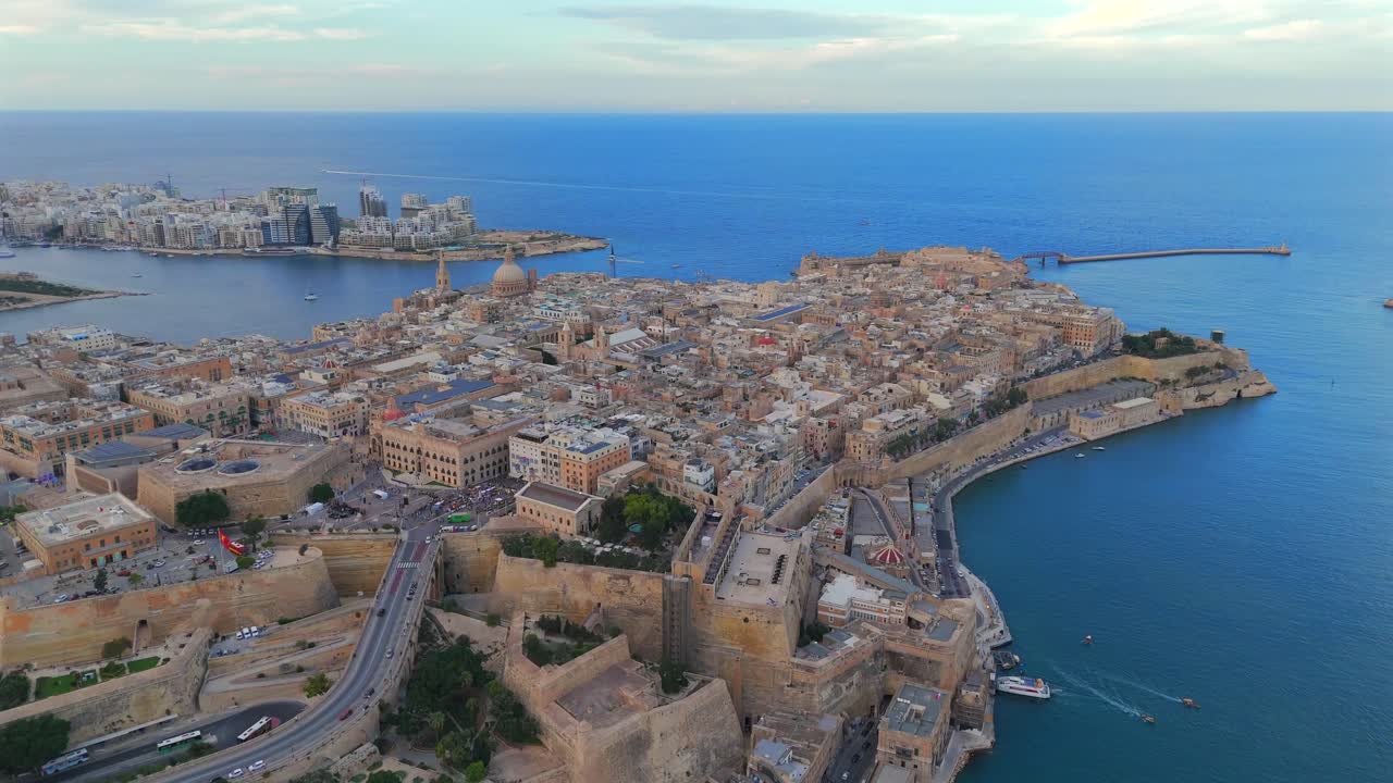 Splendide riprese aeree con drone catturano lo skyline storico de La Valletta, con la sua architettura barocca e le fortificazioni circondate dalle acque blu di Malta.