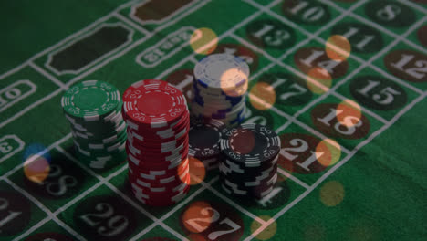 animation of spots of light over close up of a stack of casino poker chips on a table