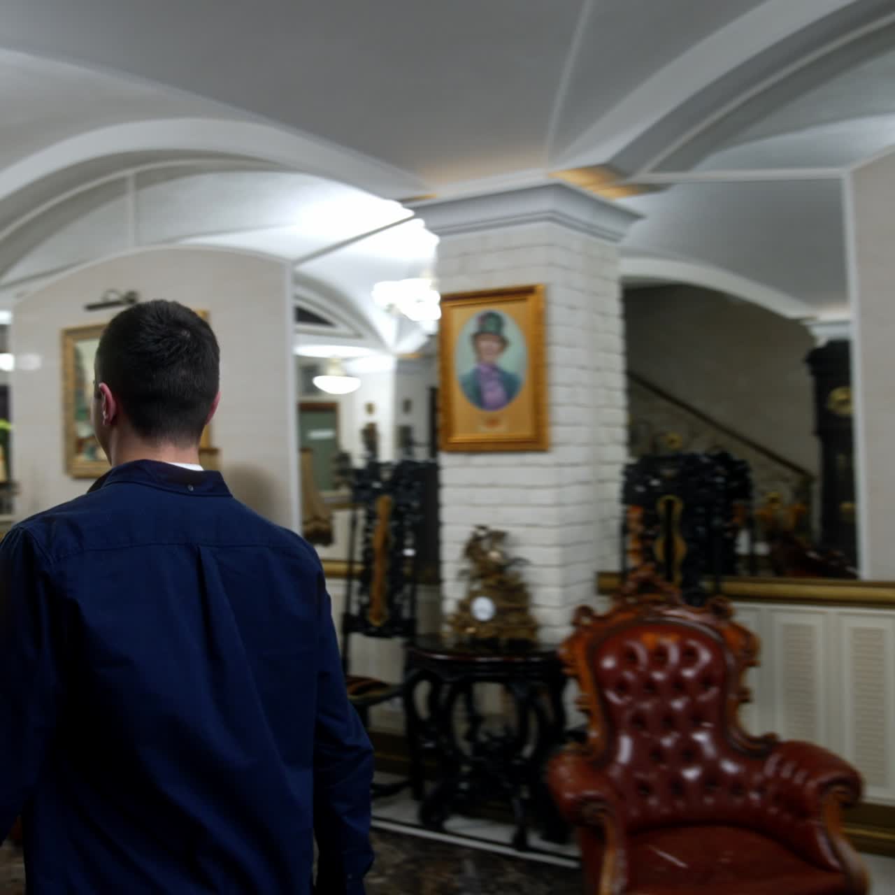 Young couple entering the cozy well-furnished hotel. People walk along the hall and come up to the reception with two female receptionists