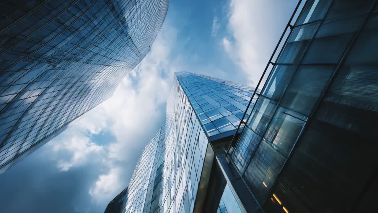 A breathtaking view that captures the towering structures of modern architecture, showcasing the reflective glass facades of skyscrapers against a dynamic sky filled with clouds, merging technology with design