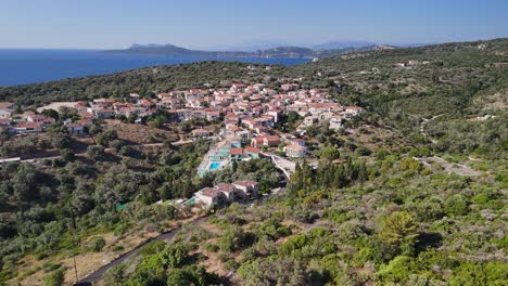 flyover hilly terrain to katomeri, greek village with ionian sea beyond